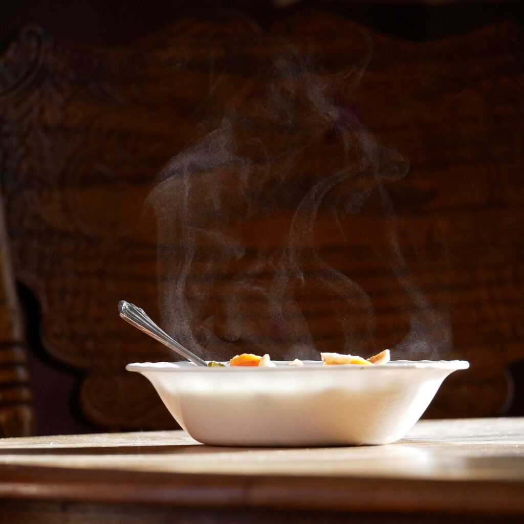 food, soup, hot, sunlight, vegetables, bowl, spoon, chair, wooden table, wooden chair, steam